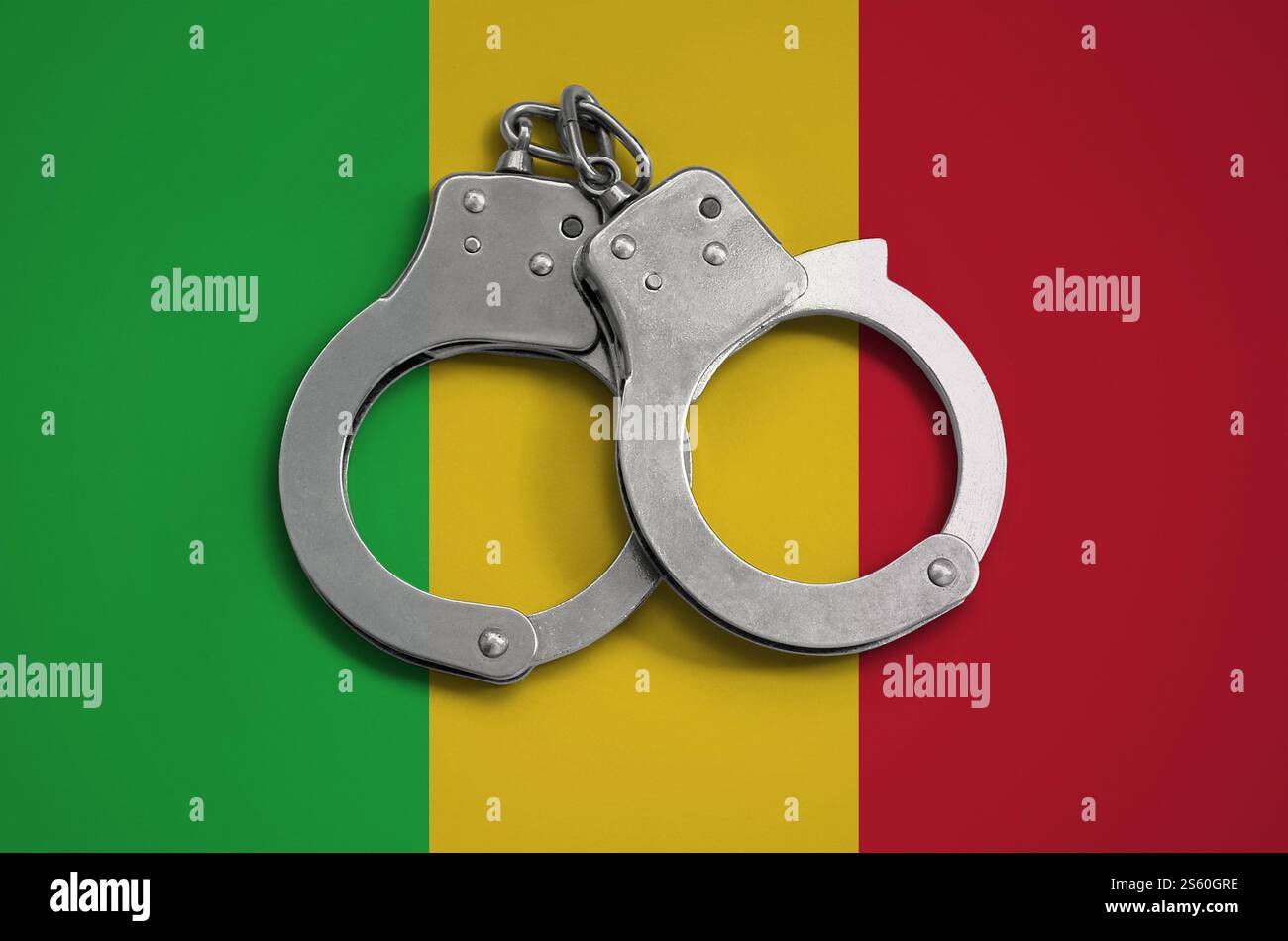 Drapeau du Mali et menottes policières. La notion de respect de la loi dans le pays et de protection contre la criminalité. Drapeau du Mali et menottes policières. Le Banque D'Images