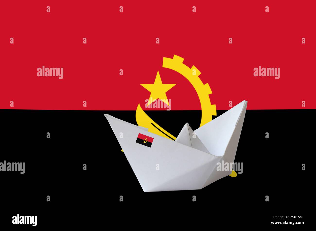 Drapeau de l'Angola représenté sur un navire en origami en papier en gros plan. Concept d'arts orientaux faits à la main. Drapeau de l'Angola représenté sur un navire en origami en papier en gros plan. Arts faits main Banque D'Images