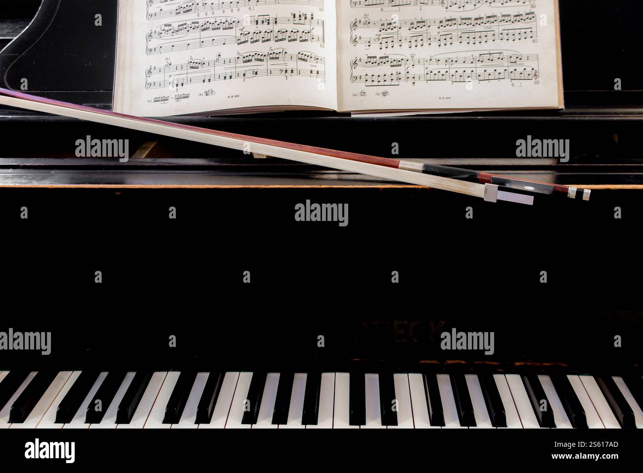 Un arc de violoncelle et un piano avec partition classique prêt pour un duo à jouer Banque D'Images