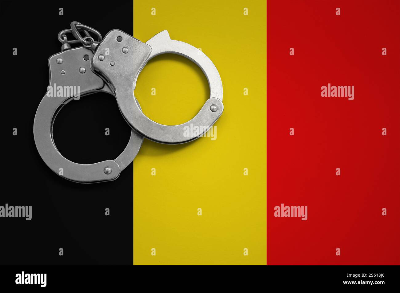Drapeau belge et menottes de police. La notion de crime et de délits dans le pays. Drapeau belge et menottes de police. Le concept de crime et Banque D'Images