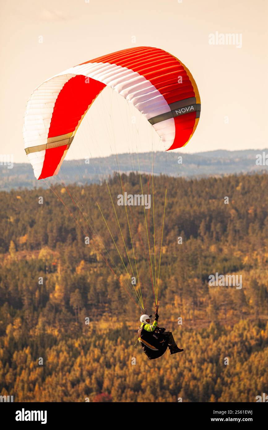 Le parapente s'élève au-dessus d'un paysage d'automne par un après-midi ensoleillé Banque D'Images
