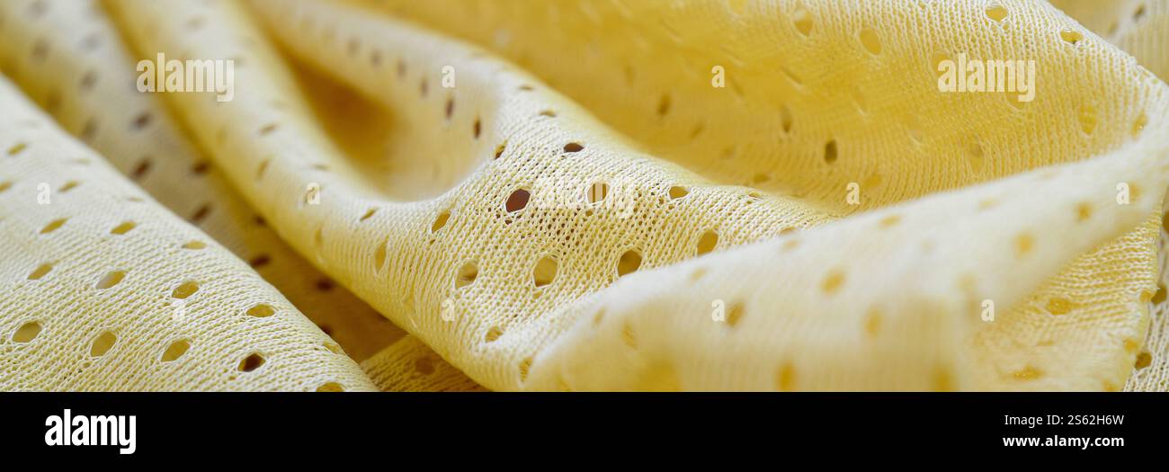 Fond de modèle textile de tissu de tissu de sport de maille jaune. Couleur jaune maillot de football vêtements tissu texture vêtements de sport. Poreux respirant Banque D'Images