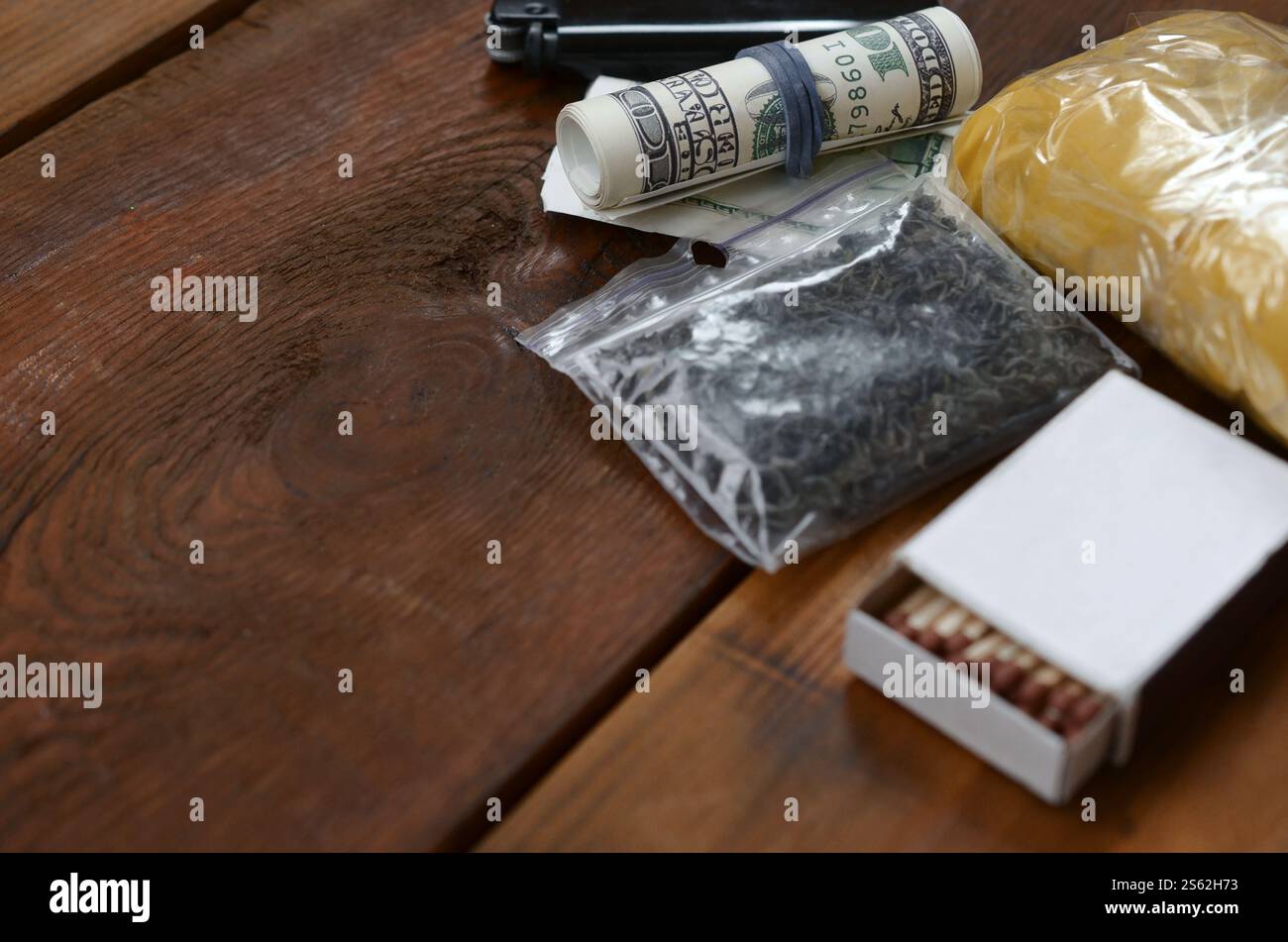 Articles pour préparer et rouler le joint de marijuana cannabis. Drogues concept narcotique. Petits paquets de substance sèche noire et argent américain. Éléments pour Banque D'Images