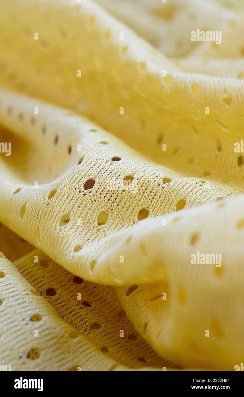 Fond de modèle textile de tissu de tissu de sport de maille jaune. Couleur jaune maillot de football vêtements tissu texture vêtements de sport. Poreux respirant Banque D'Images