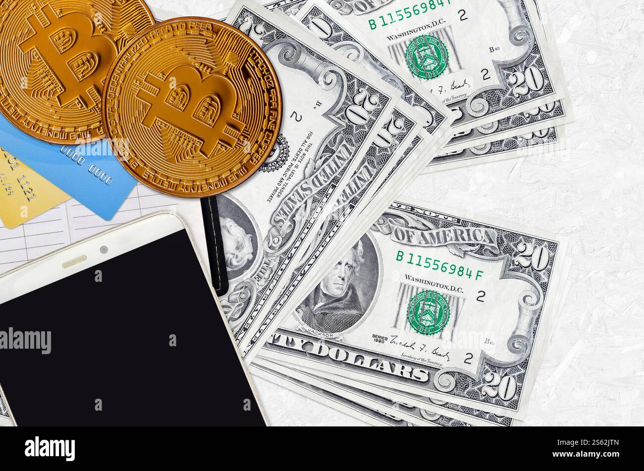 Billets de 20 dollars américains et bitcoins dorés avec smartphone et cartes de crédit. Concept d'investissement en crypto-monnaie. Crypto-minage ou transactions de trading. Banque D'Images