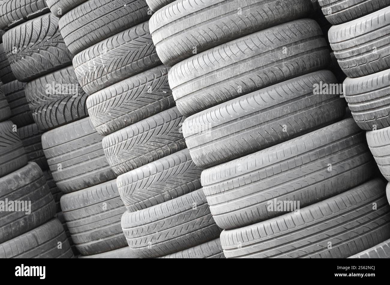 Vieux pneus usagés empilés avec des piles élevées dans le garage secondaire de magasin de pièces de voiture de près. Vieux pneus usagés empilés avec des piles élevées dans des pièces de voiture secondaires Banque D'Images