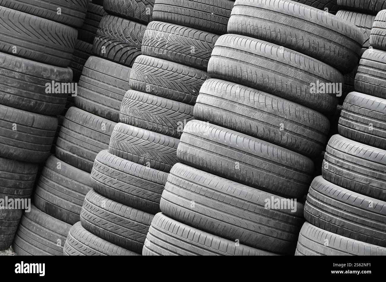 Vieux pneus usagés empilés avec des piles élevées dans le garage secondaire de magasin de pièces de voiture de près. Vieux pneus usagés empilés avec des piles élevées dans des pièces de voiture secondaires Banque D'Images