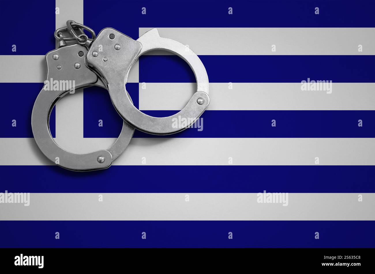 Drapeau grec et menottes de police. La notion de crime et de délits dans le pays. Drapeau grec et menottes de police. Le concept de crime et Banque D'Images