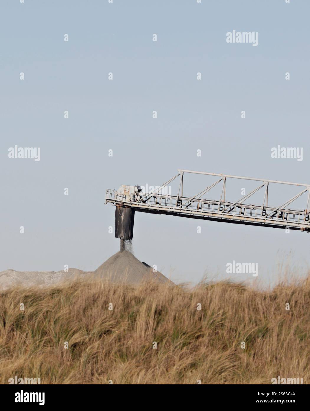 Importation de granit concassé agrégé s'écoulant de la pousse du convoyeur Banque D'Images