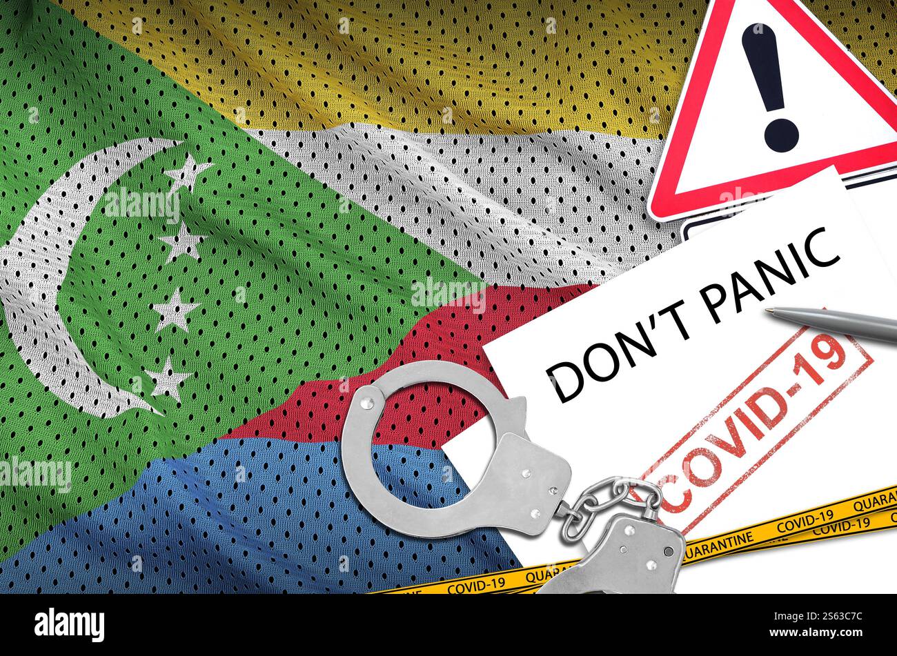 Drapeau des Comores et menottes de police avec inscription dont Panic sur papier blanc. Concept de coronavirus ou virus pandémique 2019-nCoV. Drapeau des Comores et Banque D'Images