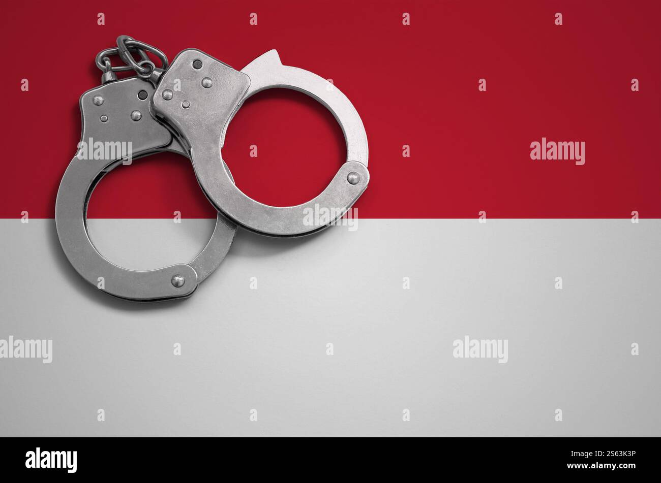 Drapeau de Monaco et menottes de police. La notion de crime et de délits dans le pays. Drapeau de Monaco et menottes de police. Le concept de crime et Banque D'Images