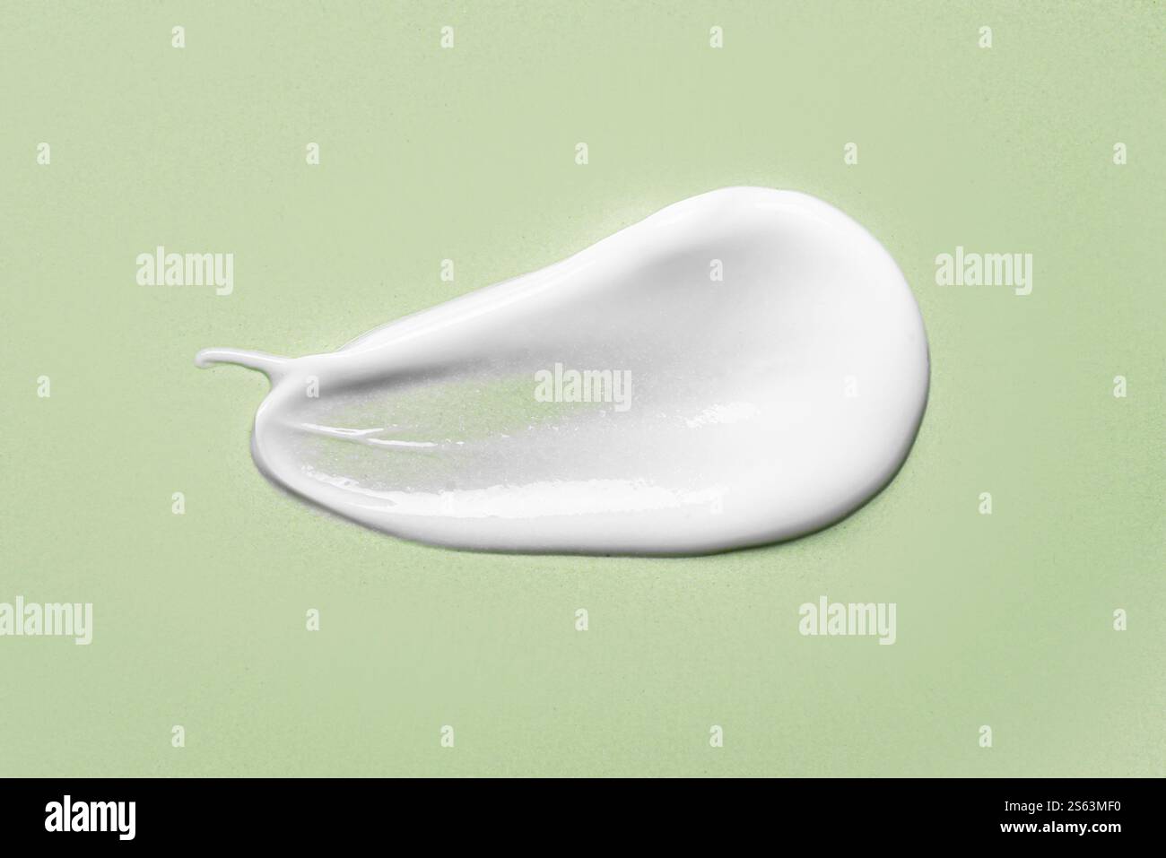 Hydratant gel crème cosmétique blanc frottis sur fond vert gros plan. Nuance de texture de sérum de lotion de soin pour le visage. Échantillon de produit de beauté. Banque D'Images