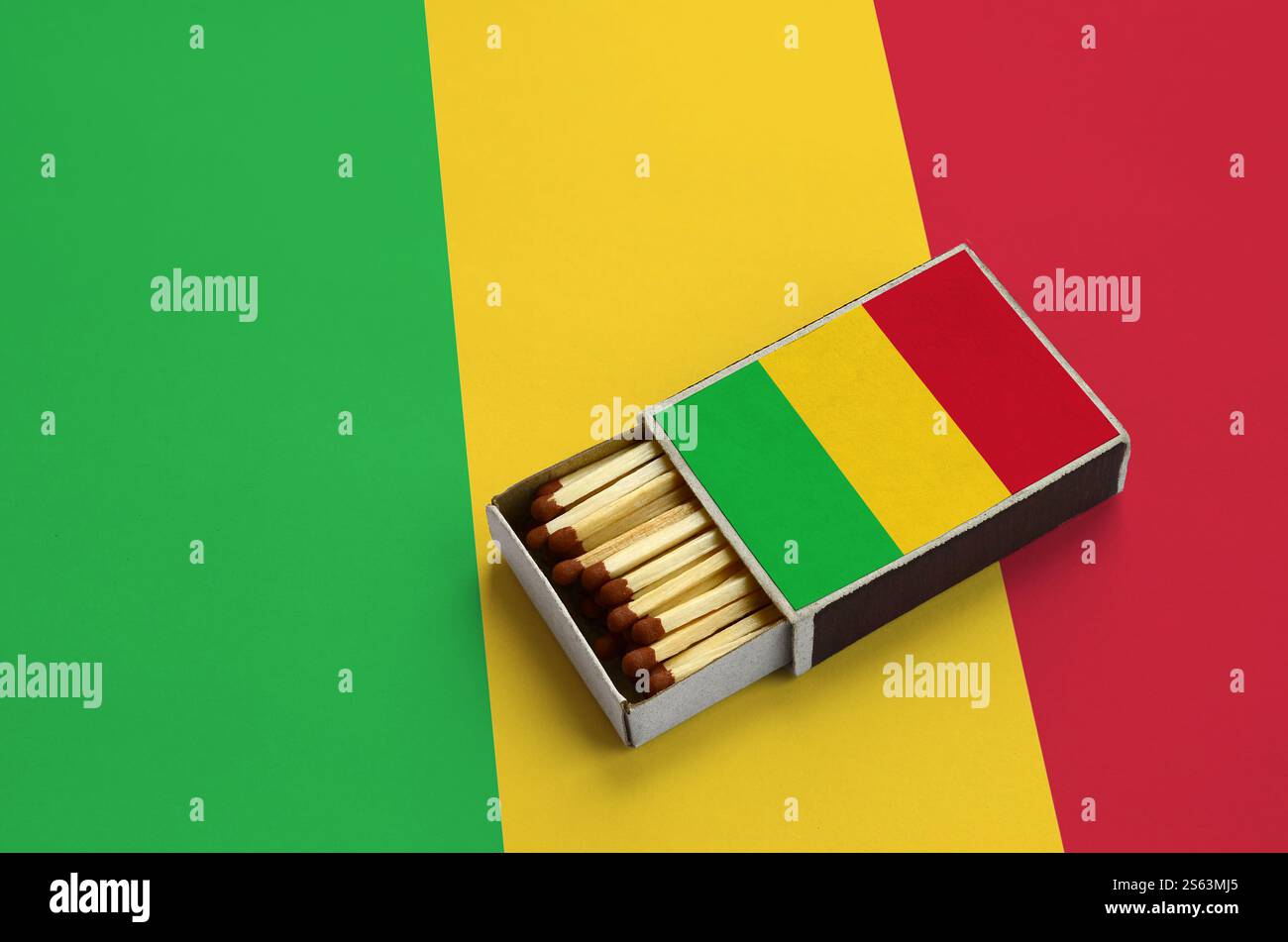 Le drapeau du Mali est représenté dans une boîte d'allumettes ouverte, remplie d'allumettes et reposant sur un grand drapeau. Le drapeau Mali est affiché dans une boîte d'allumettes ouverte, qui est Banque D'Images