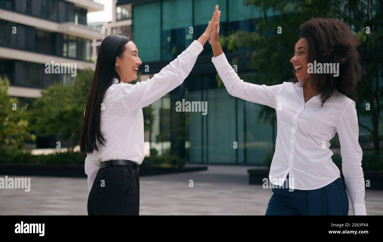 Afro-américaine asiatique coréenne femmes ensemble heureux rire femmes d'affaires partenaires d'affaires coworkers donner haut cinq bonne ville de travail d'équipe Banque D'Images