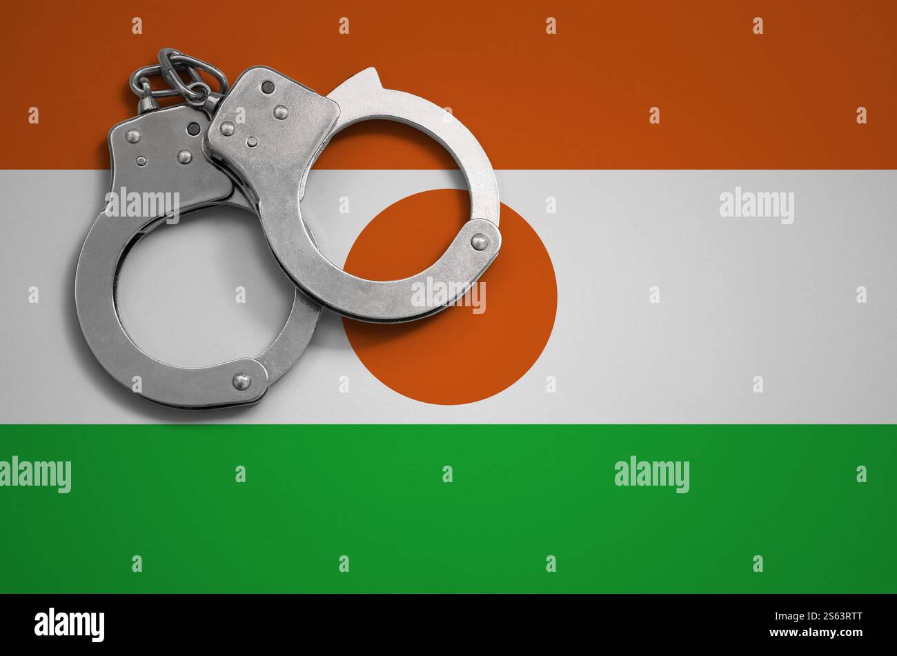 Drapeau du Niger et menottes policières. La notion de crime et de délits dans le pays. Drapeau du Niger et menottes policières. La notion de crime et de délits Banque D'Images