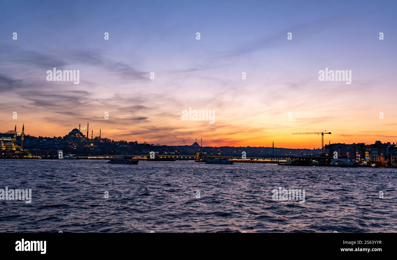 Photographie panoramique haute résolution capturant la péninsule historique d'Istanbul baignée d'un coucher de soleil cramoisi. Les silhouettes emblématiques de la ville Banque D'Images