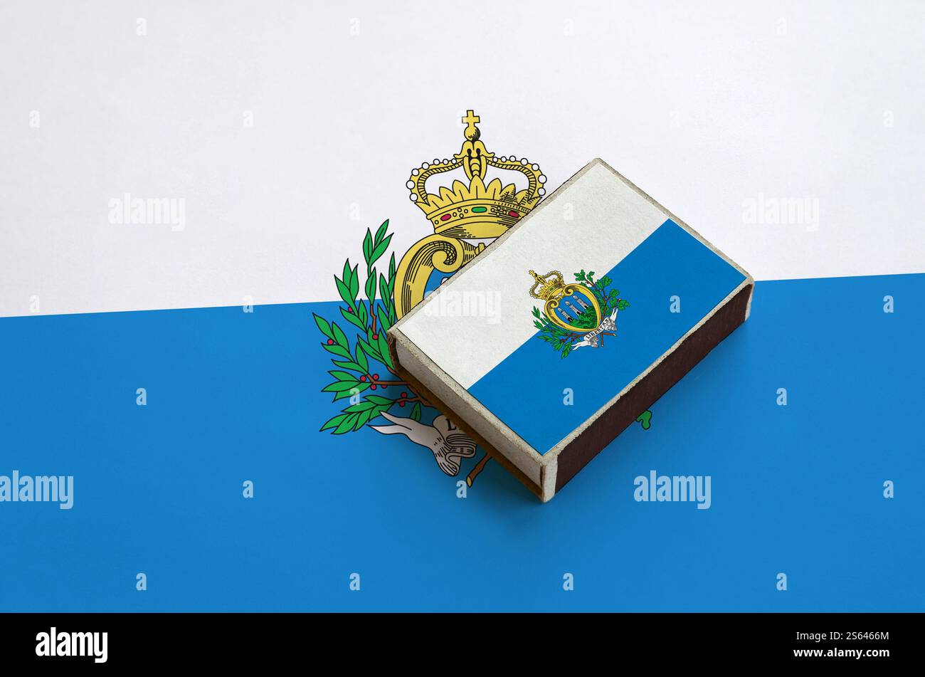 Le drapeau de Saint-Marin est représenté sur une boîte d'allumettes qui repose sur un grand drapeau. Le drapeau de Saint-Marin est représenté sur une boîte d'allumettes qui repose sur un grand drapeau Banque D'Images