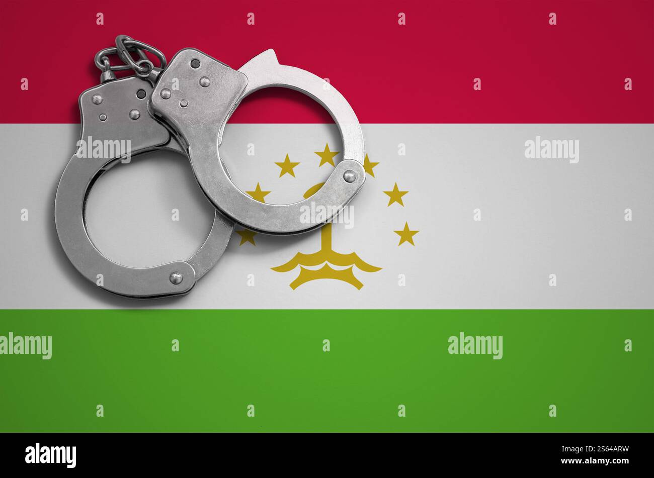 Drapeau du Tadjikistan et menottes de police. La notion de crime et de délits dans le pays. Drapeau du Tadjikistan et menottes de police. Le concept de crime Banque D'Images