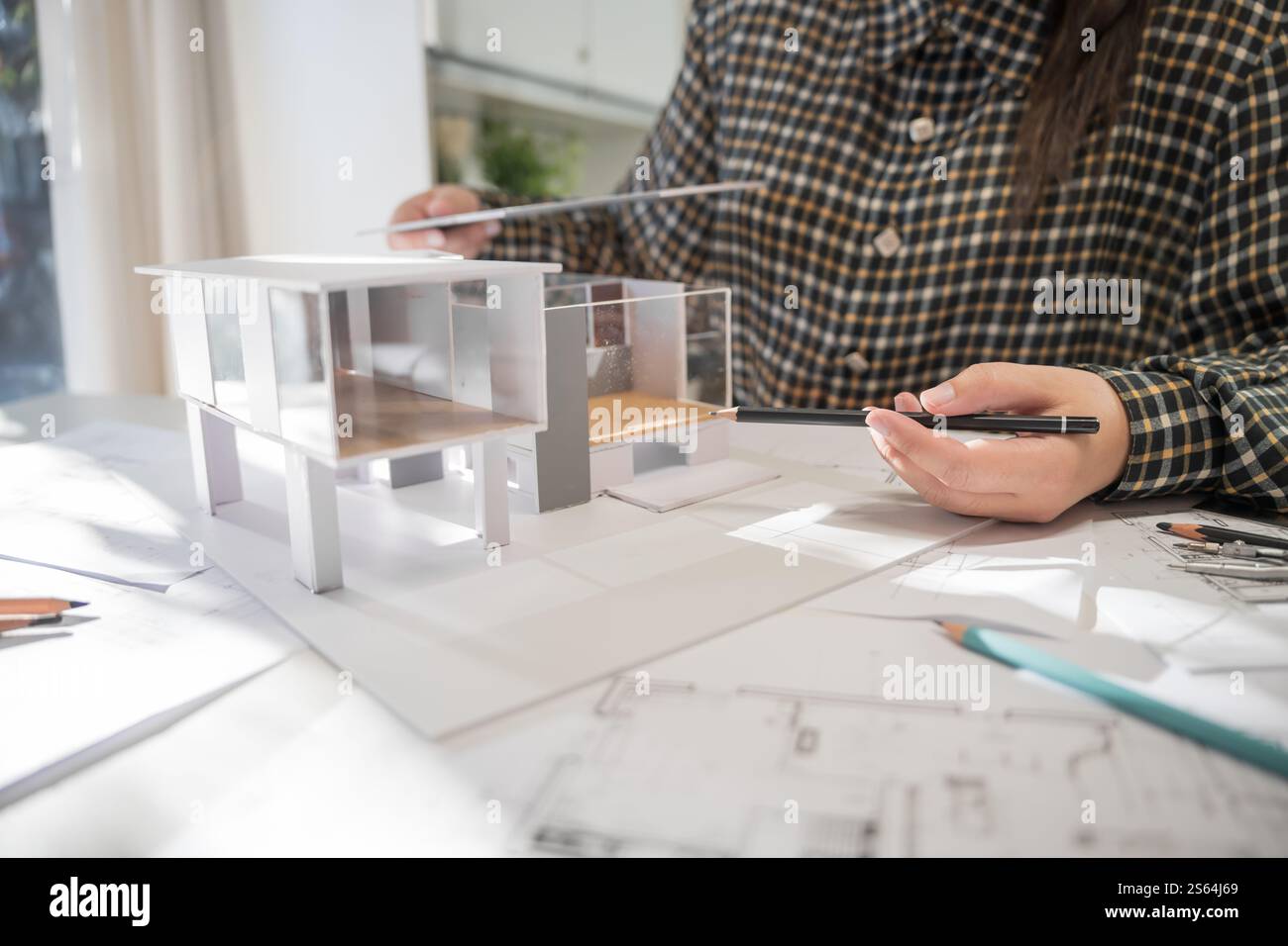 Modèle de maison sur Buleprint construction dessin et équipement de dessin stationnaire architecte analysant maison modèle moderne dans la main architecte Design Banque D'Images