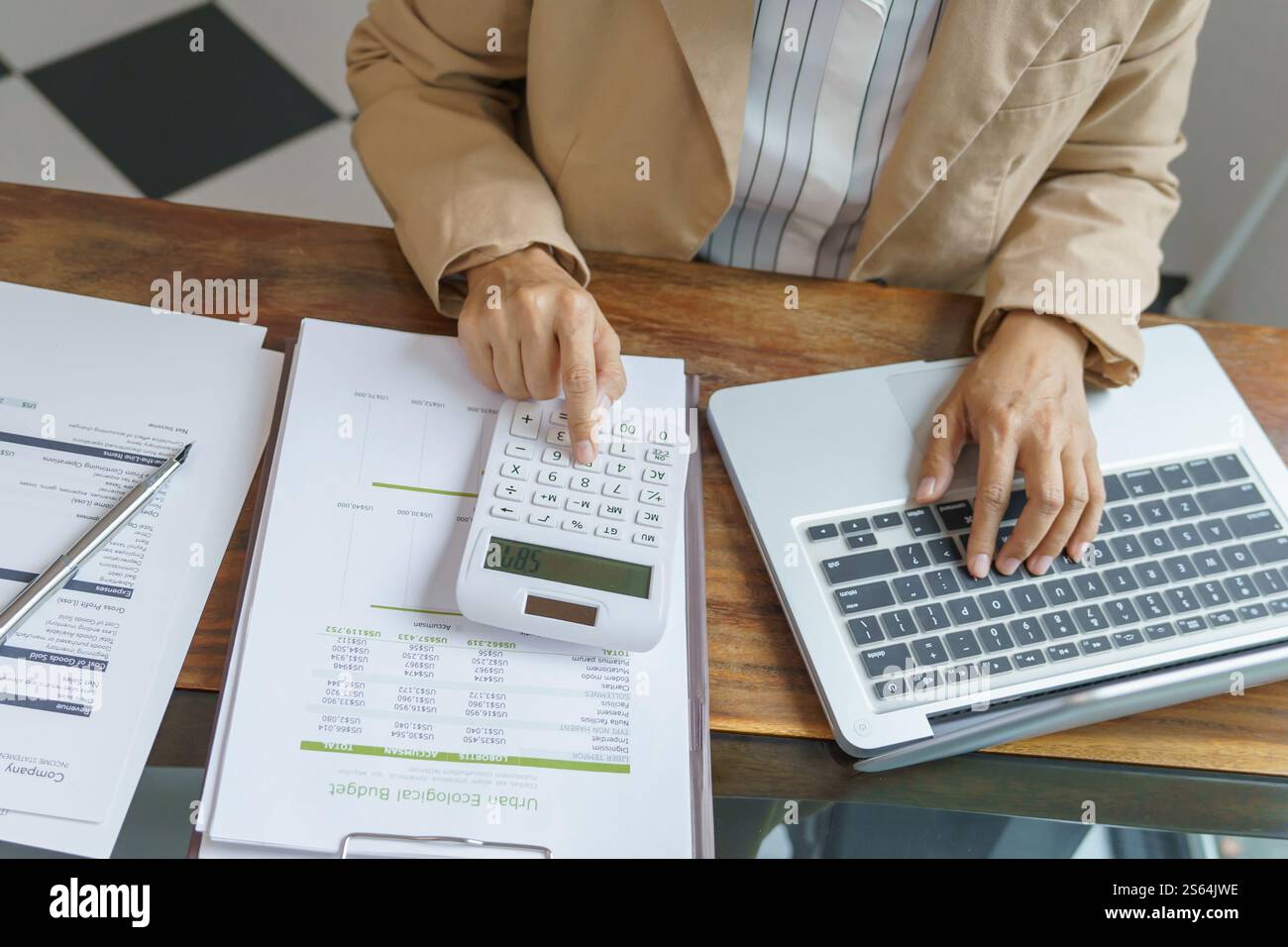 Femme d'affaires calculant l'état financier sur la calculatrice de déclaration d'impôt en ligne et de paiement Banque D'Images