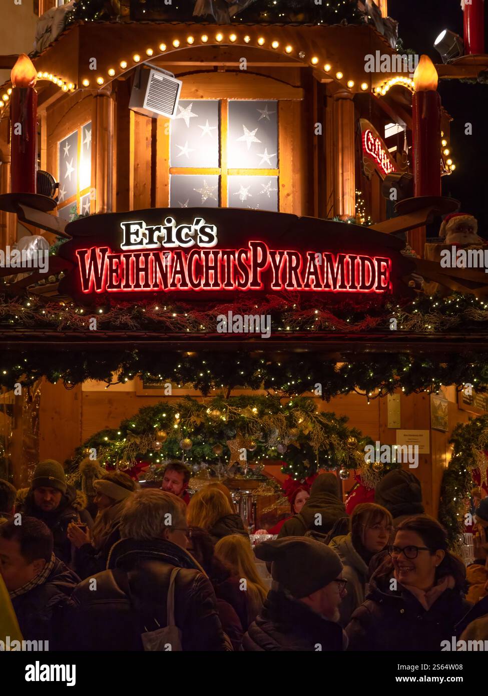 Bâle, Suisse - 23 décembre 2024 : les gens se sont rassemblés devant l'étal de la pyramide de Noël d'Eric au marché de Noël de Bâle Banque D'Images