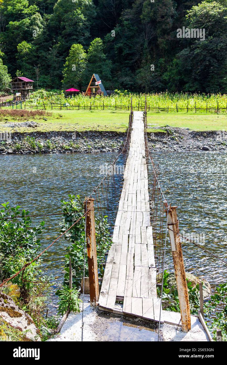 Voyage à la Géorgie - vue du pont suspendu avec plancher de bois dans le village de Machakhlispiri sur la rivière Machakhelistsqali en Adjara le jour ensoleillé de l'automne Banque D'Images