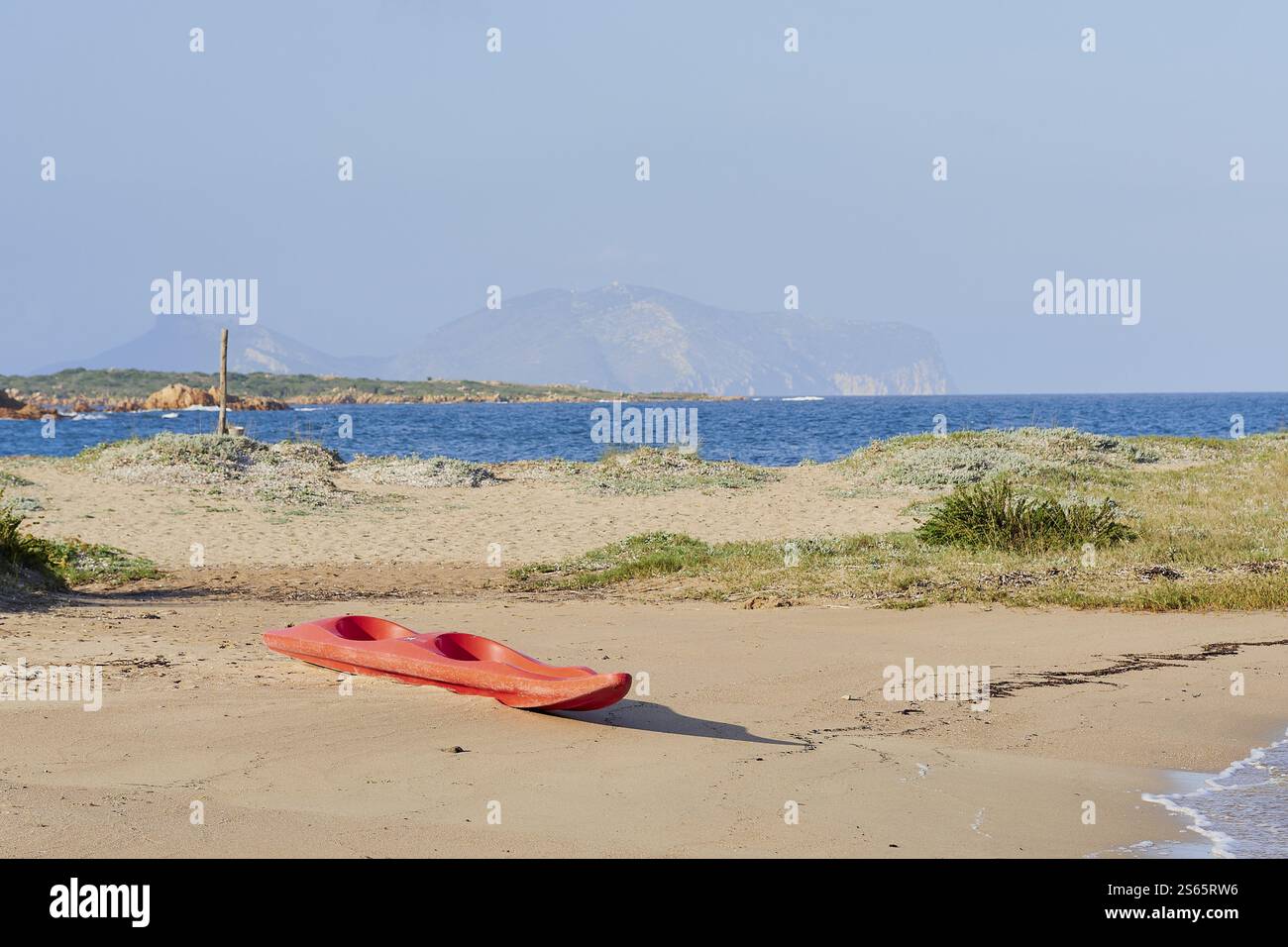 Une photo d'un kayak rouge sur la plage Banque D'Images