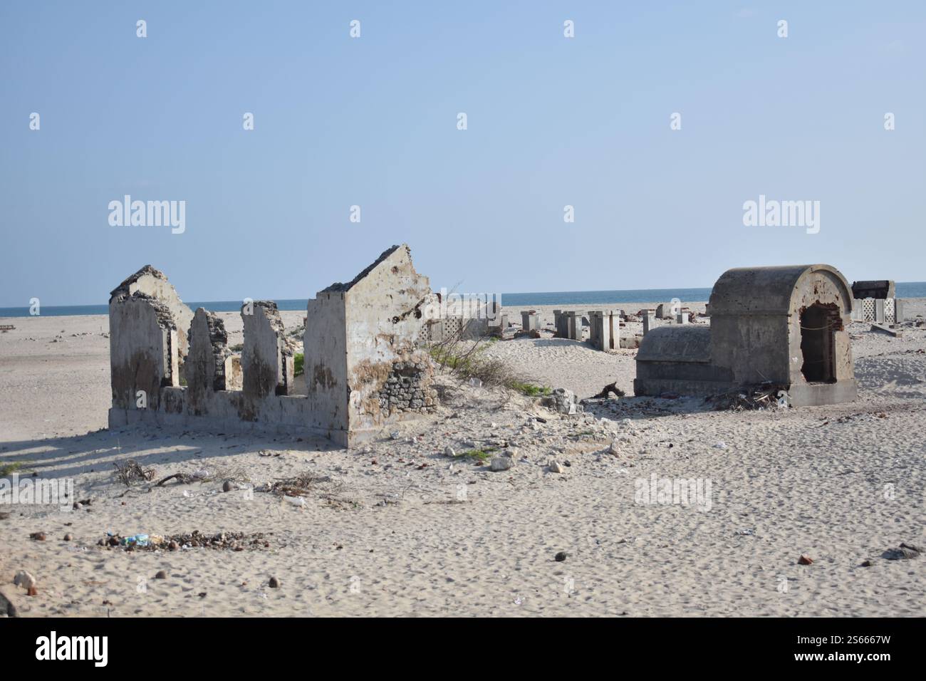 Ruines d'une colonie déserte à Dhanushkodi, Rameswaram, Inde, avec l'océan serein en arrière-plan Banque D'Images