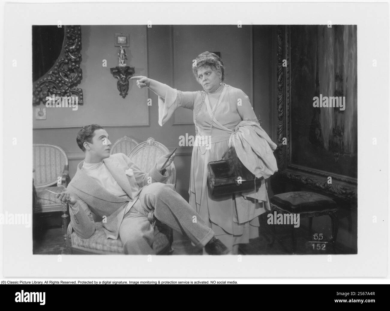 Son Altesse Royale les bardeaux. Un film muet de 1928 mettant en vedette le chilien Enrique Rivero dans le rôle de Nickolo, qui travaille dans le salon de coiffure de son grand-père et est un expert en bardeaux. Une façon de créer la coiffure, inspirée de l'Amérique et devenue à la mode dans les années 1920 L'actrice Karin Swanström s'exprime avec force lors du tournage d'une scène de film et semble gronder le jeune homme. Le film a été présenté en première suédoise au Röda Kvarn le 13 février 1928. Banque D'Images