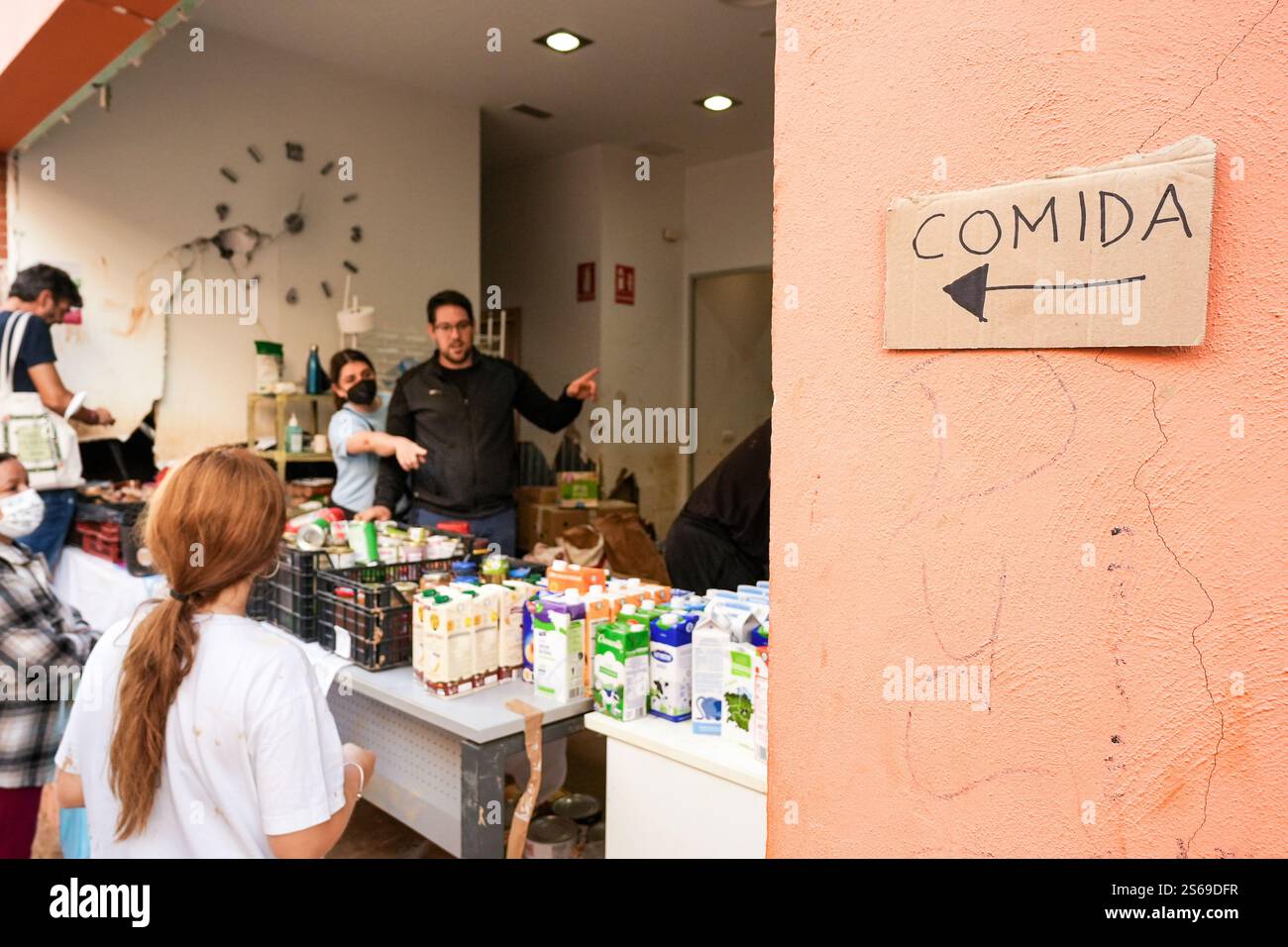 Les gens reçoivent de la nourriture gratuite dans un point de distribution de nourriture géré par des bénévoles dans la Communauté valencienne, Espagne. Banque D'Images