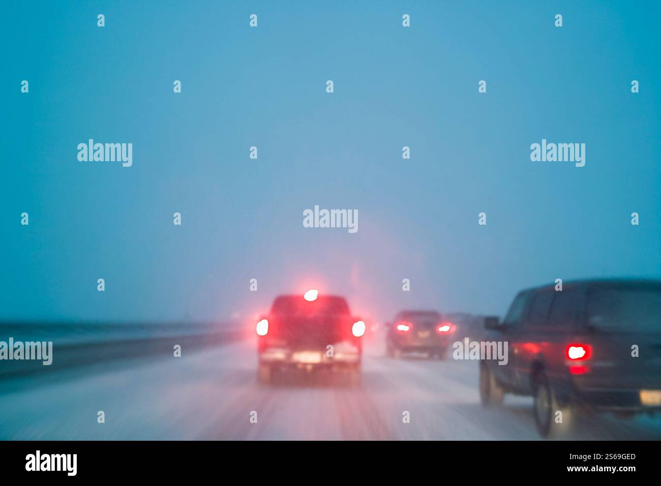Conduite dans de mauvaises conditions météorologiques avec de la neige sur autoroute de nuit, flou de mouvement à longue exposition dans l'appareil photo Banque D'Images