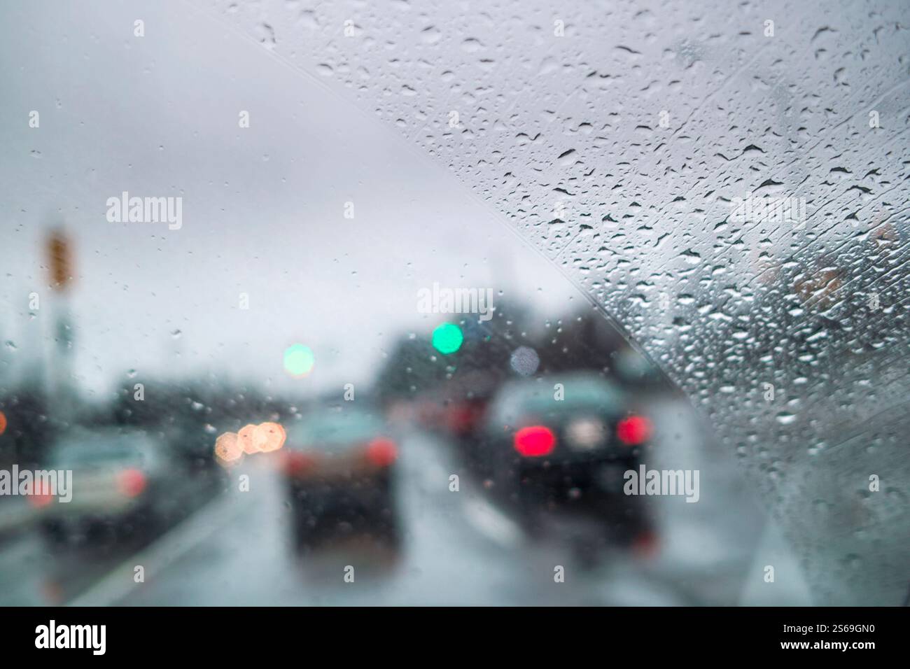 Voitures conduisant dans de mauvaises conditions météorologiques avec du brouillard et de fortes pluies sur la rue de la ville vu à travers le pare-brise Banque D'Images