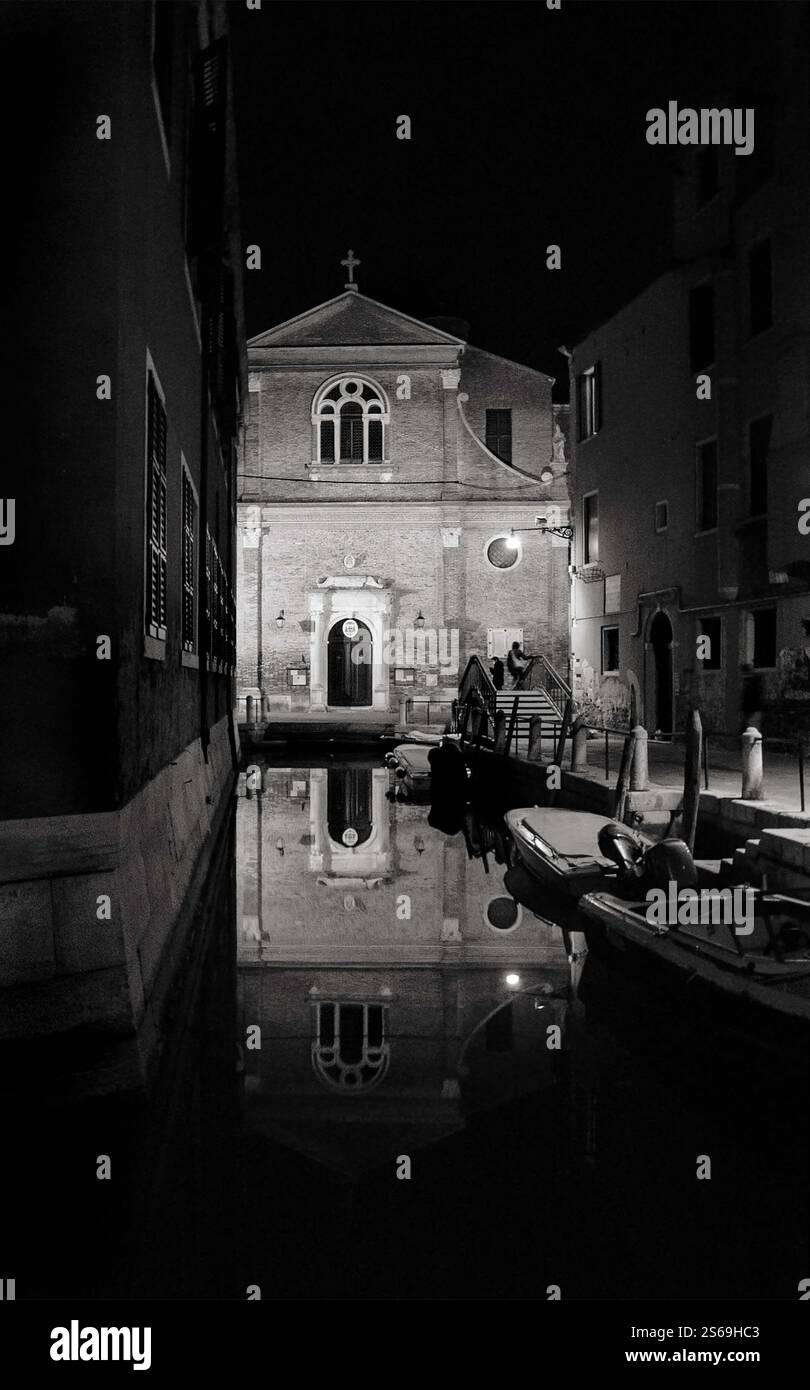 Réflexions du paysage de Venise. Église San Martino reflétée dans l'eau du canal la nuit en hiver. Venise, Italie. Photo historique noir et blanc. Banque D'Images