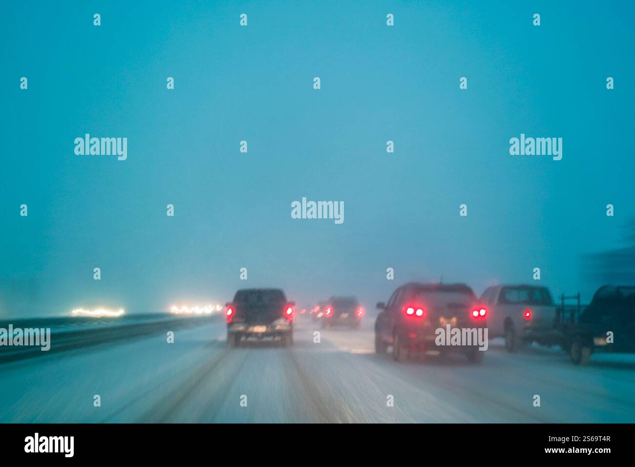 Conduite dans de mauvaises conditions météorologiques avec de la neige sur autoroute de nuit, flou de mouvement à longue exposition dans l'appareil photo Banque D'Images
