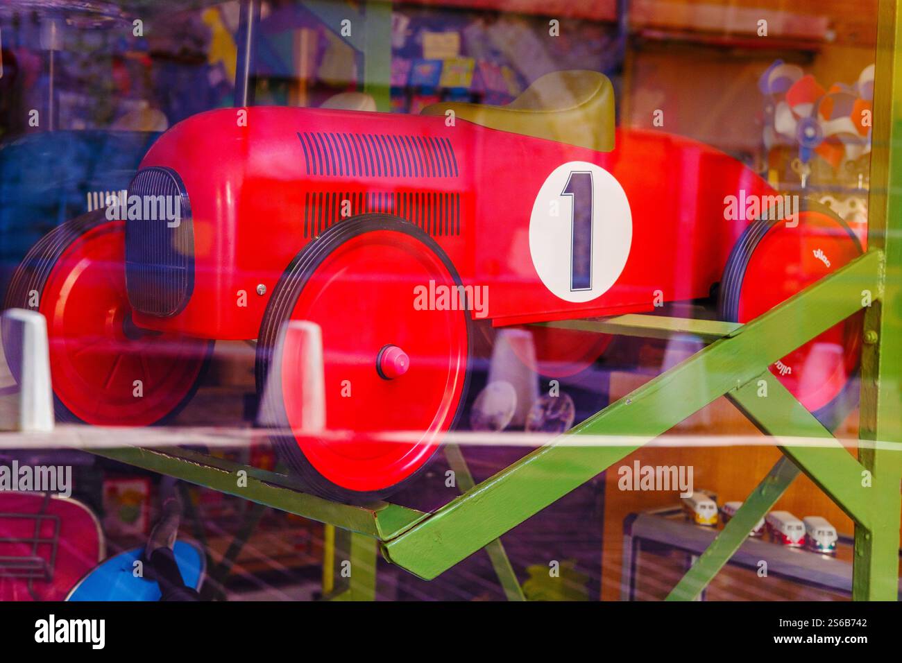 Grande voiture jouet rouge dans la fenêtre du magasin Banque D'Images