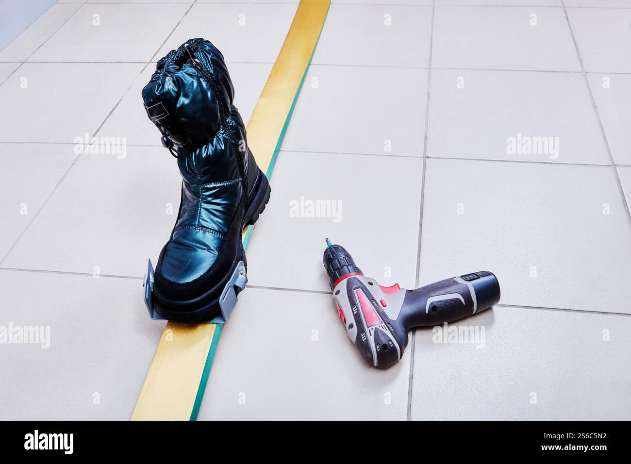 La chaussure pour femme est insérée dans le support de la fixation de ski universelle pour marquer le coussin de talon pendant l'installation. Banque D'Images