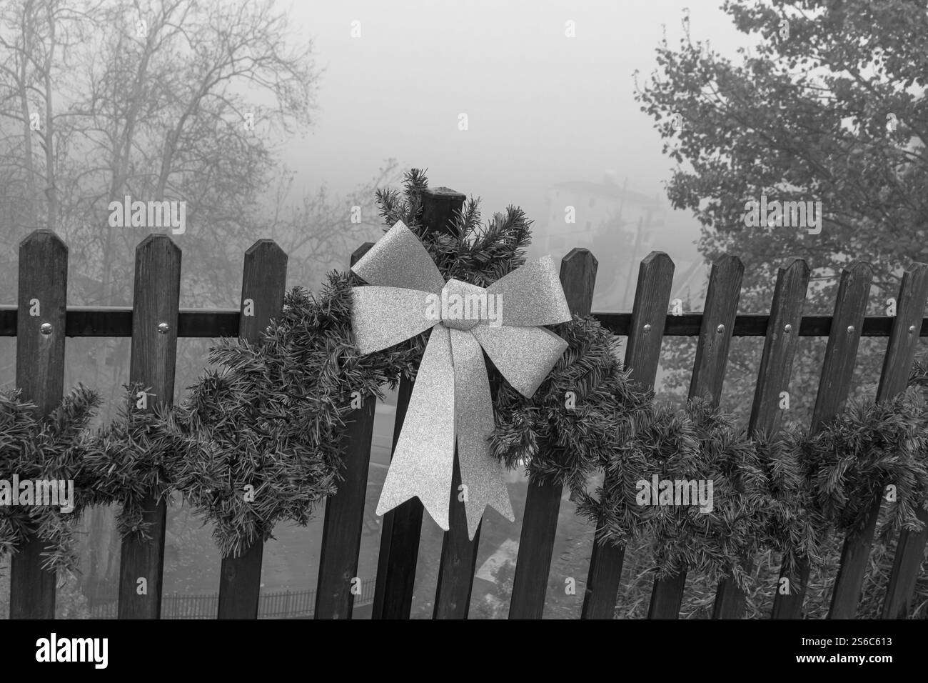 Noël Noël paillettes roses scintillantes décoration d'arc sur guirlande verte le jour d'hiver brumeux Banque D'Images