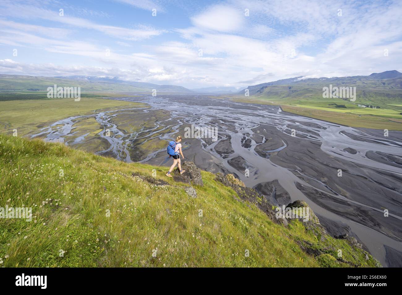 Randonneur, jeune femme sur une colline, vue sur des terres alluviales, rivière sinueuse, Dimonarhellir, SuÃ°urland, Islande, Europe Banque D'Images