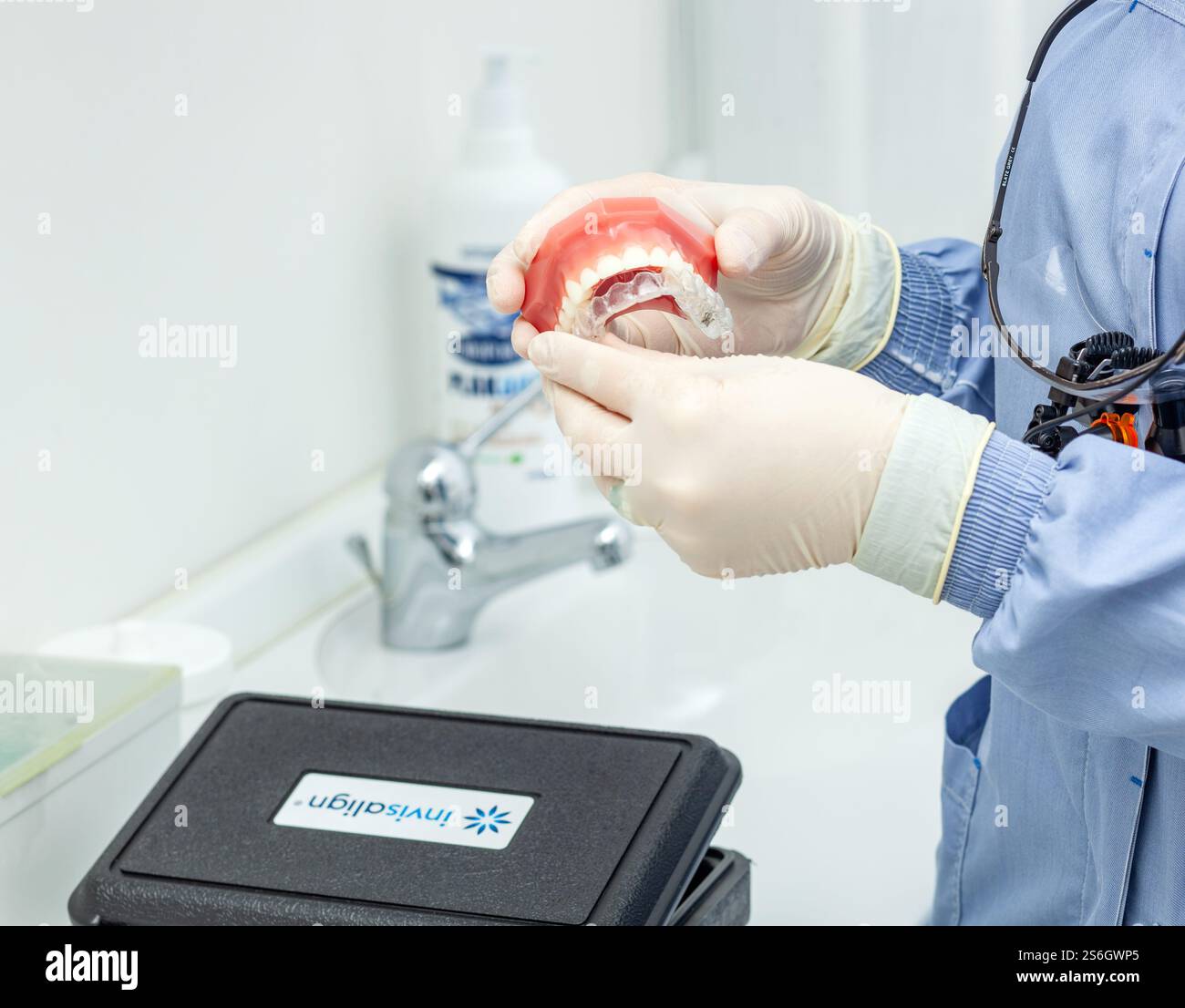 Empoli, Italie - 19 décembre 2024 : dentiste portant des gants et tenant un moule dentaire avec Invisalign dans une clinique dentaire moderne, mettant l'accent sur patien Banque D'Images