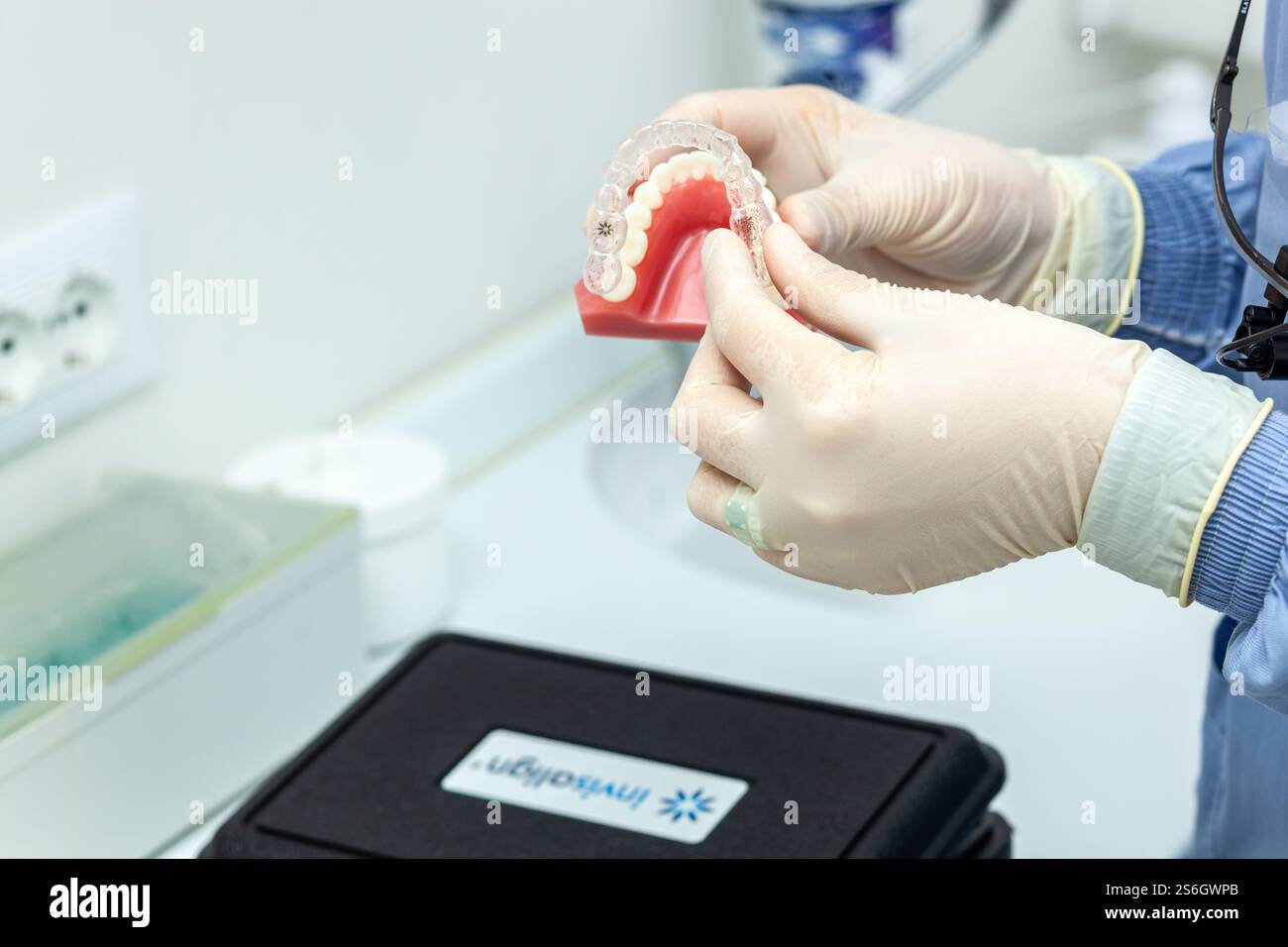 Empoli, Italie - 19 décembre 2024 : dentiste portant des gants en latex plaçant un appareil orthodontique invisalign sur un moule dentaire dans une clinique dentaire Banque D'Images