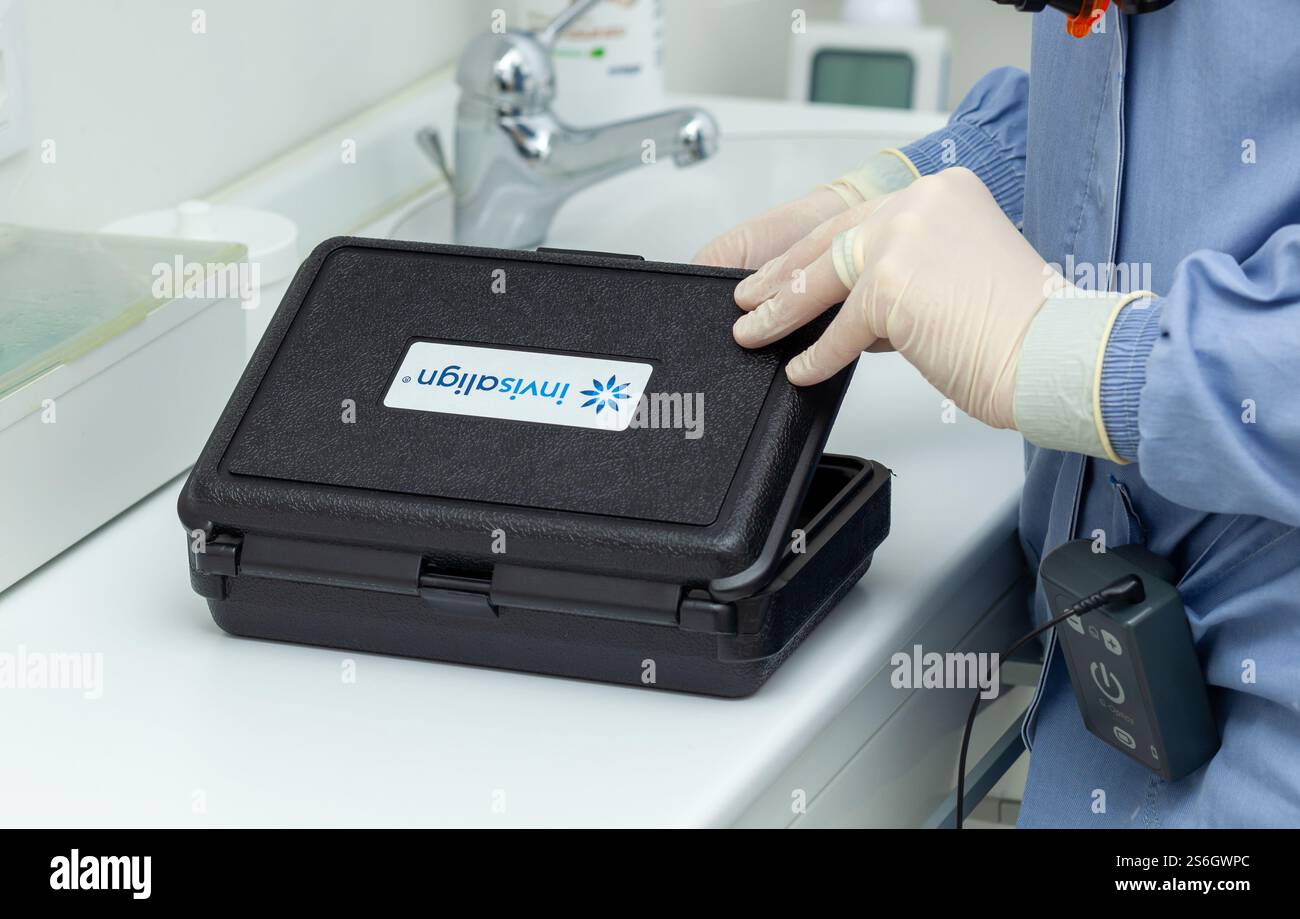 Empoli, Italie - 19 décembre 2024 : dentiste portant des gants ouvrant une boîte Invisalign contenant un appareil orthodontique transparent dans une clinique dentaire Banque D'Images