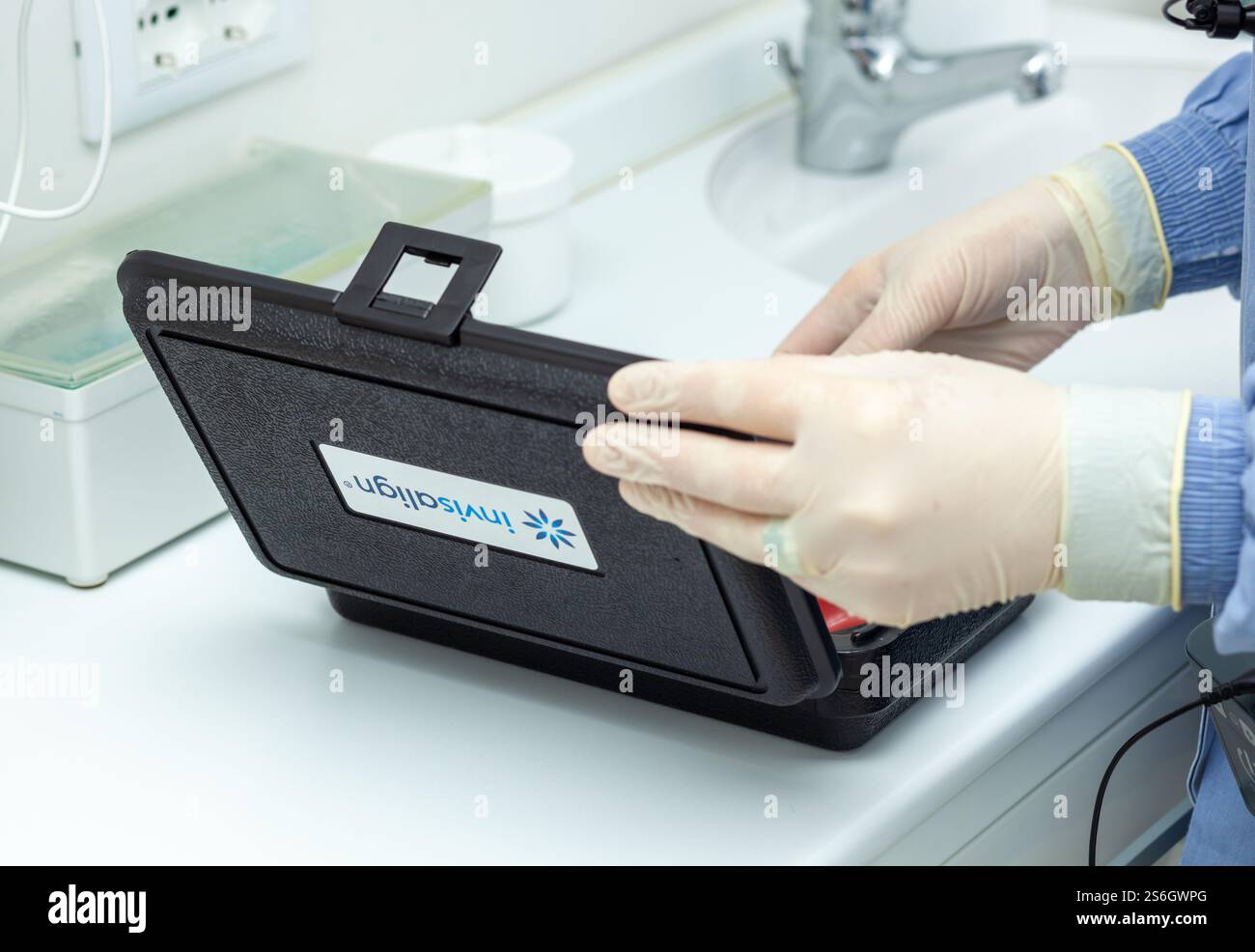 Empoli, Italie - 19 décembre 2024 : dentiste portant des gants ouvrant une boîte Invisalign contenant l'appareil orthodontique d'un patient dans une clinique dentaire Banque D'Images
