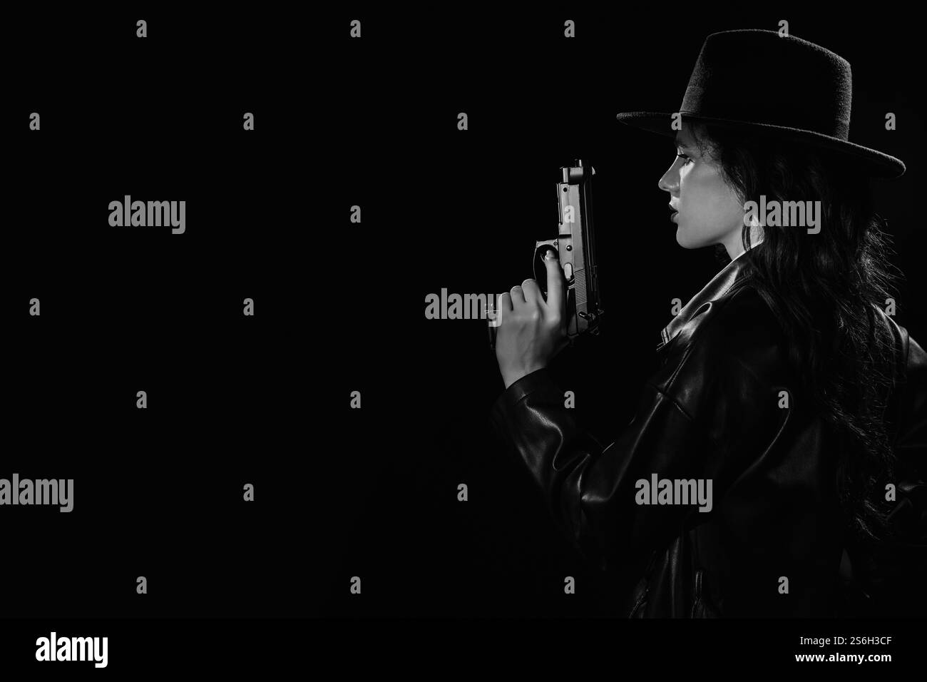 Silhouette d'une détective féminine dans un manteau et un chapeau avec un pistolet dans ses mains. Un livre drame noir portrait dans le style des détectives des années 1950 Banque D'Images