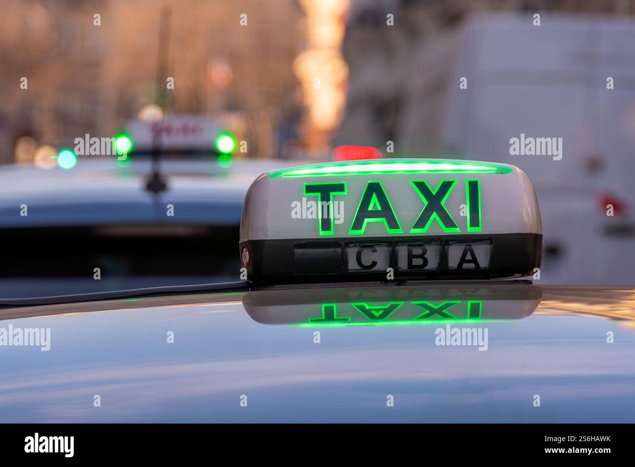 Panneau lumineux de toit avec le mot 'TAXI' allumé en vert (taxi gratuit) fixé à un véhicule stationné à une station de taxi dans une rue de Paris, France Banque D'Images Panneau lumineux de toit avec le mot 'TAXI' allumé en vert (taxi gratuit) fixé à un véhicule stationné à une station de taxi dans une rue de Paris, France Banque D'Images