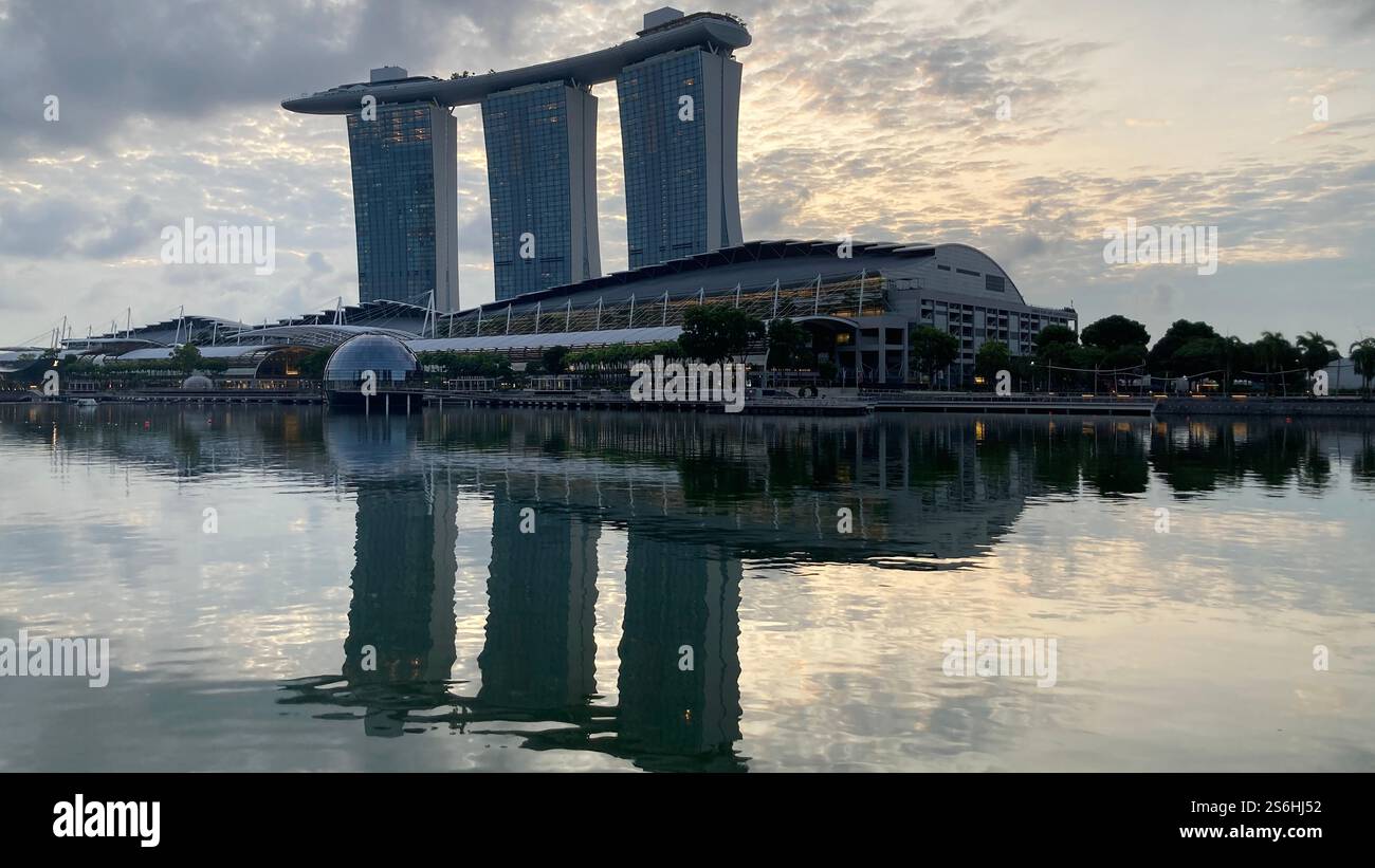 Marina Bay Sands se reflétant dans l'eau au lever du soleil Banque D'Images