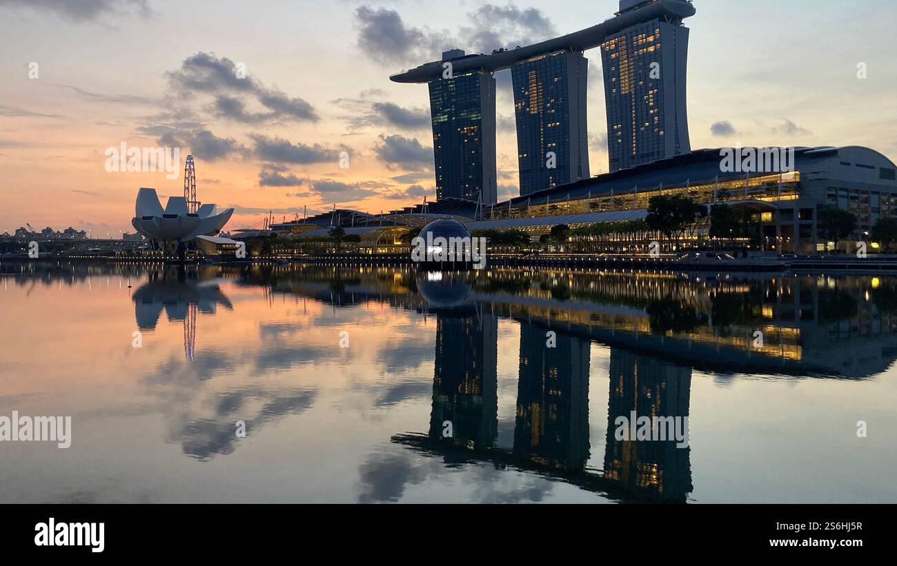 Marina Bay Sands se reflétant dans l'eau au lever du soleil Banque D'Images