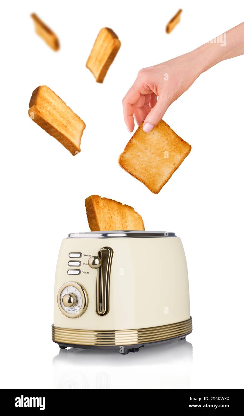 Jeune main femelle sort pain grillé toasté et morceaux de pain volant du grille-pain vintage isolé sur fond blanc avec chemin de clipping. Feu BR Banque D'Images