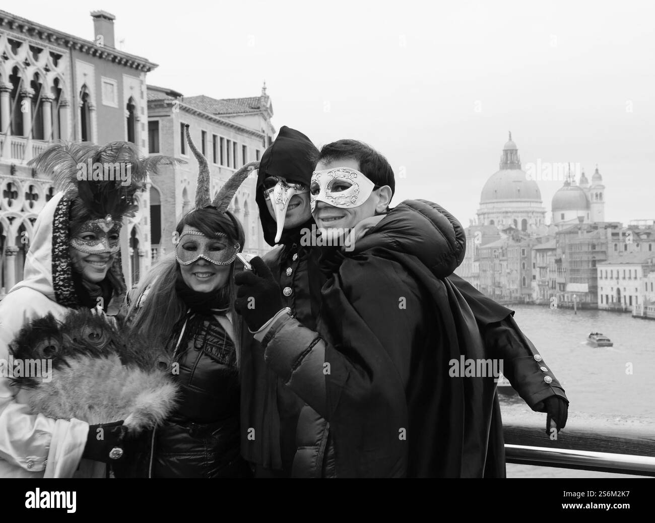 VENISE, ITALIE - 14 FÉVRIER 2015 : touristes en masque photographiés au pont de l'Accademia avec vue sur le Grand canal. Photo historique noir et blanc Banque D'Images