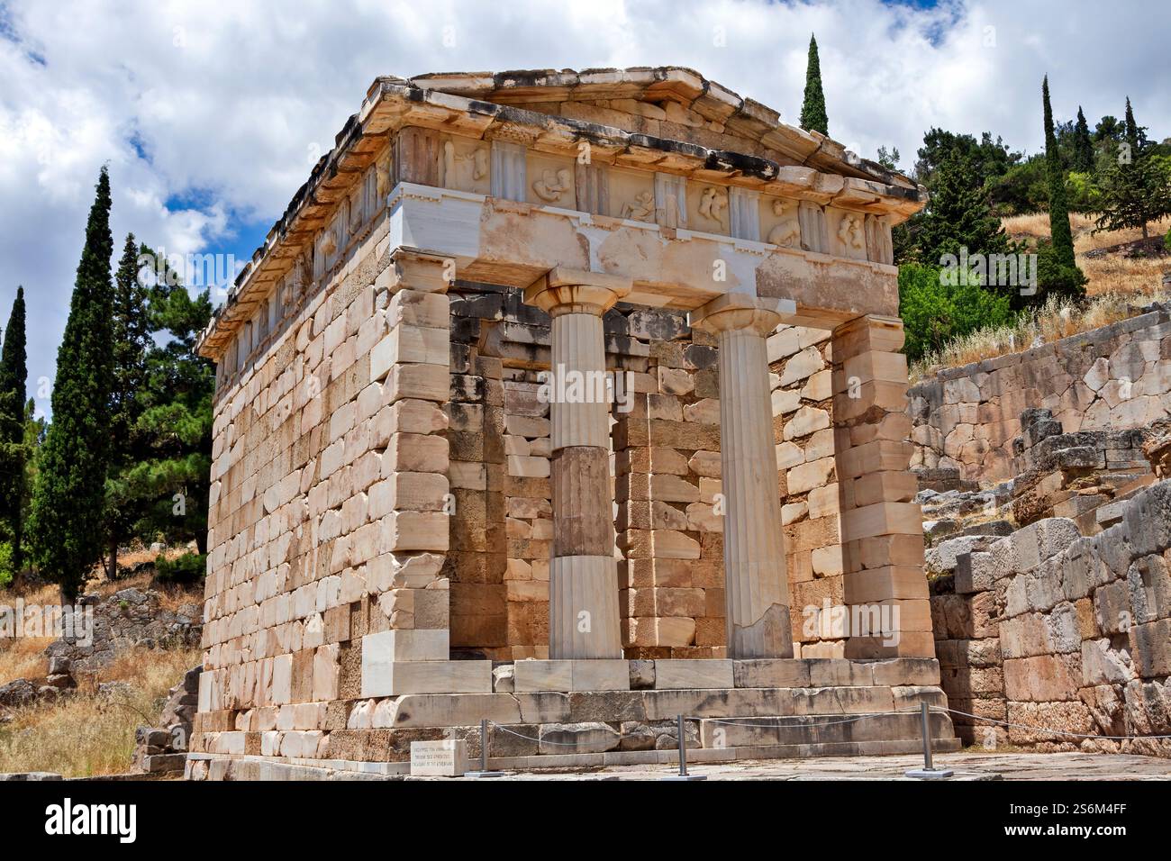 Le Trésor athénien à Delphes, en Grèce, présentant ses impressionnantes colonnes doriques et frise ornée, situé au milieu des ruines sacrées de l'ancien oracle Banque D'Images