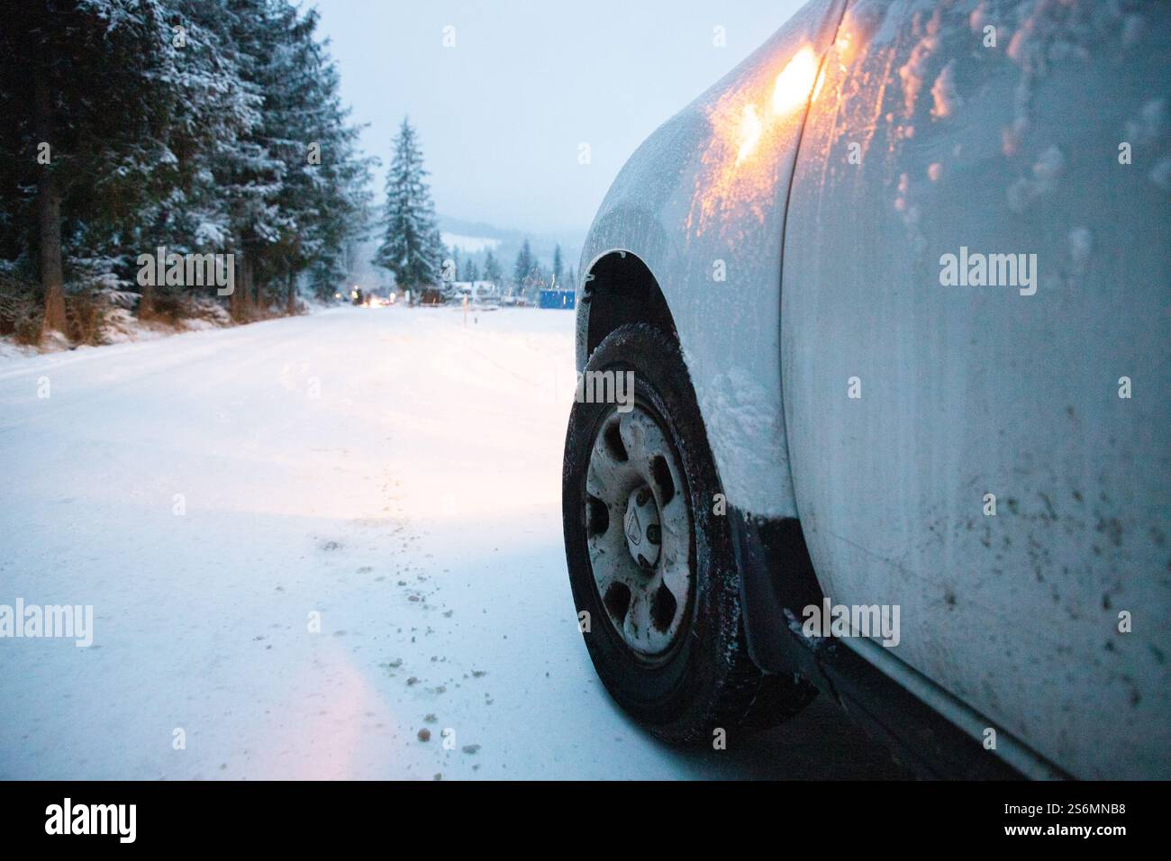 pneu d'une voiture sur une route enneigée Banque D'Images